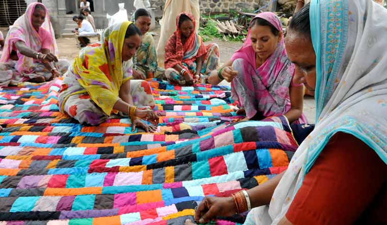 Women stitching colorful quilt